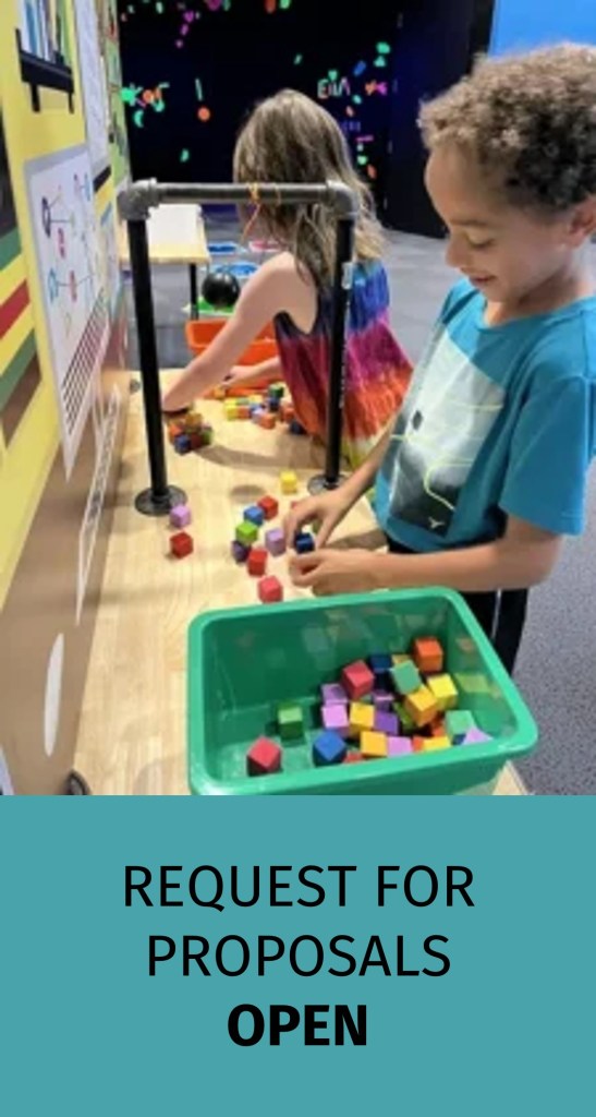 Two children interact with colorful blocks at a tabletop exhibit. Text reads "Request for Proposals Open."